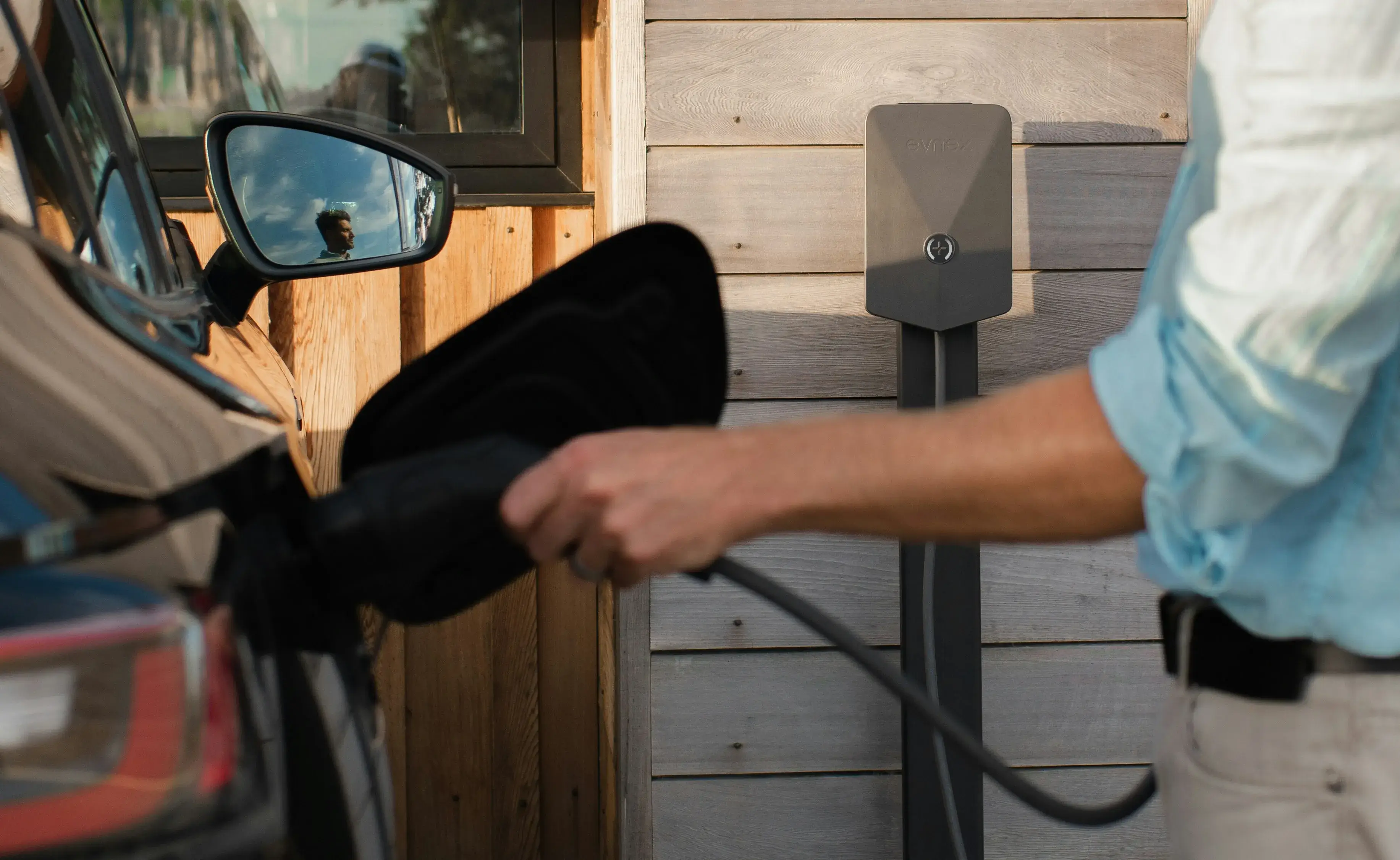 Personne rechargeant son véhicule électrique sur une borne de recharge