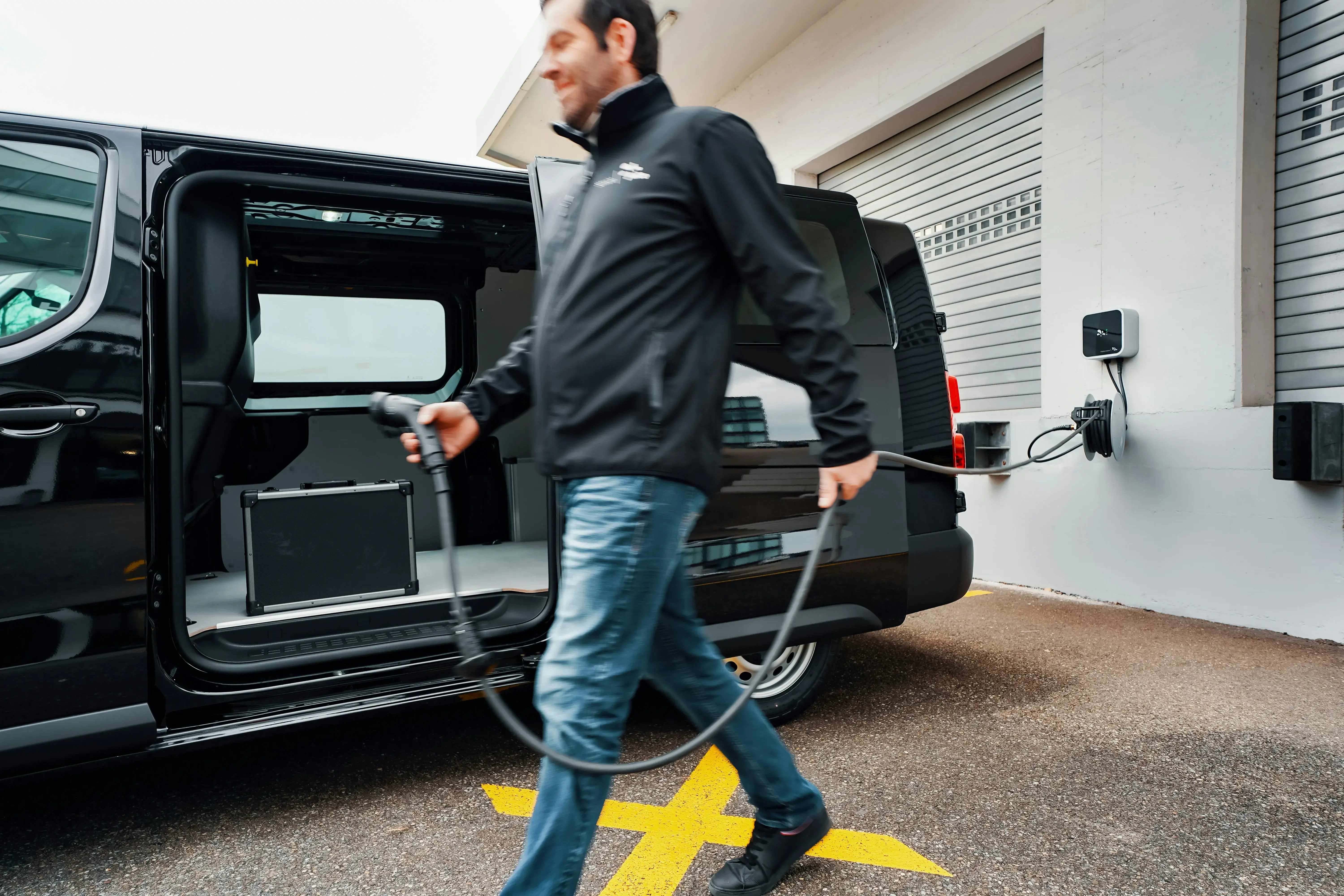 Personne rechargeant son véhicule électrique sur une borne de recharge